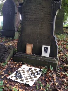 Yates’ gravestone, adorned with 2 of his books and a position from his win against Vidmar San Remo 1930